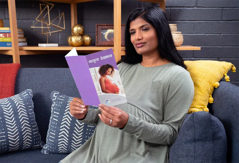 A woman reads a hand out about pregnancy